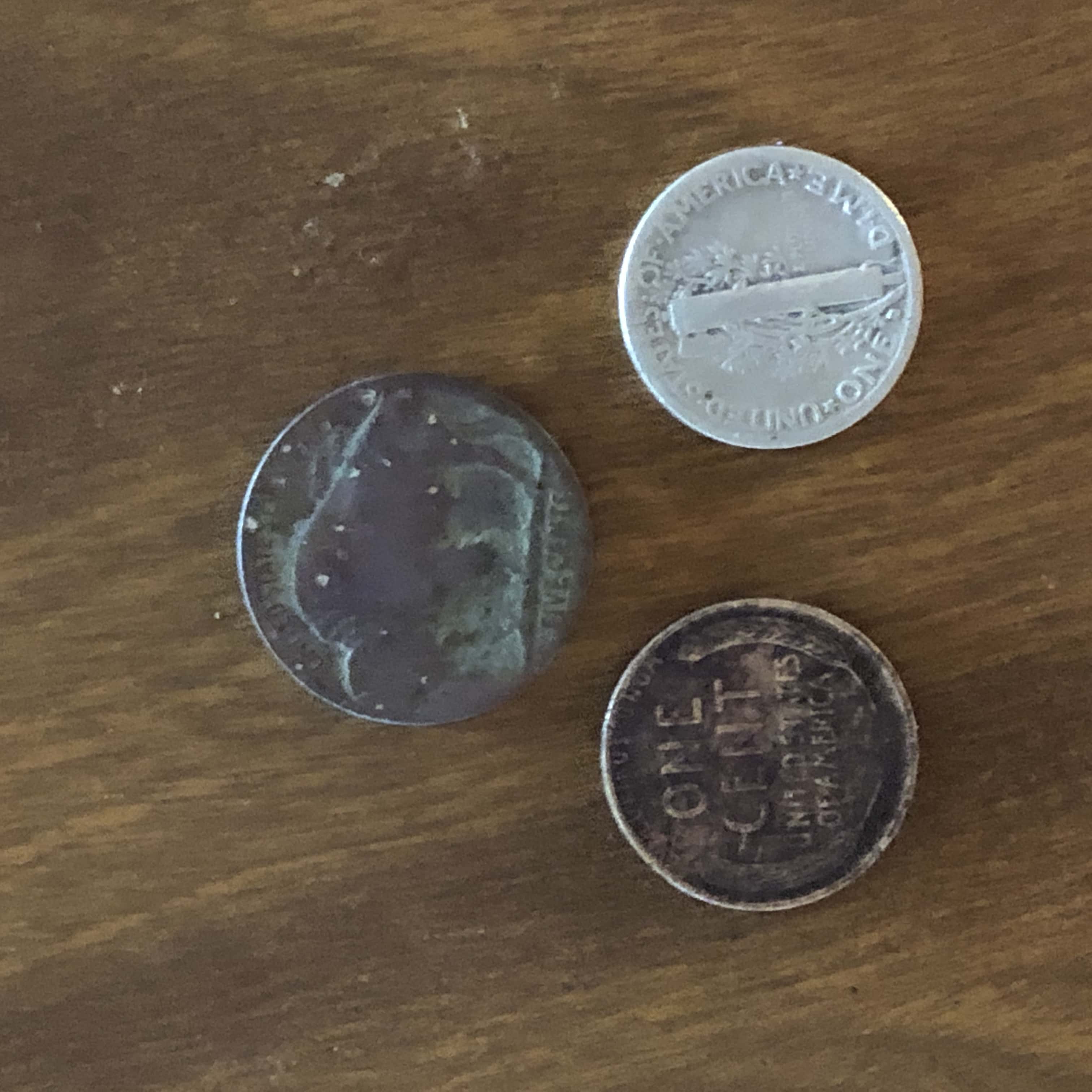 Wheat Penny and Mercury Dime on Wood Grain Background