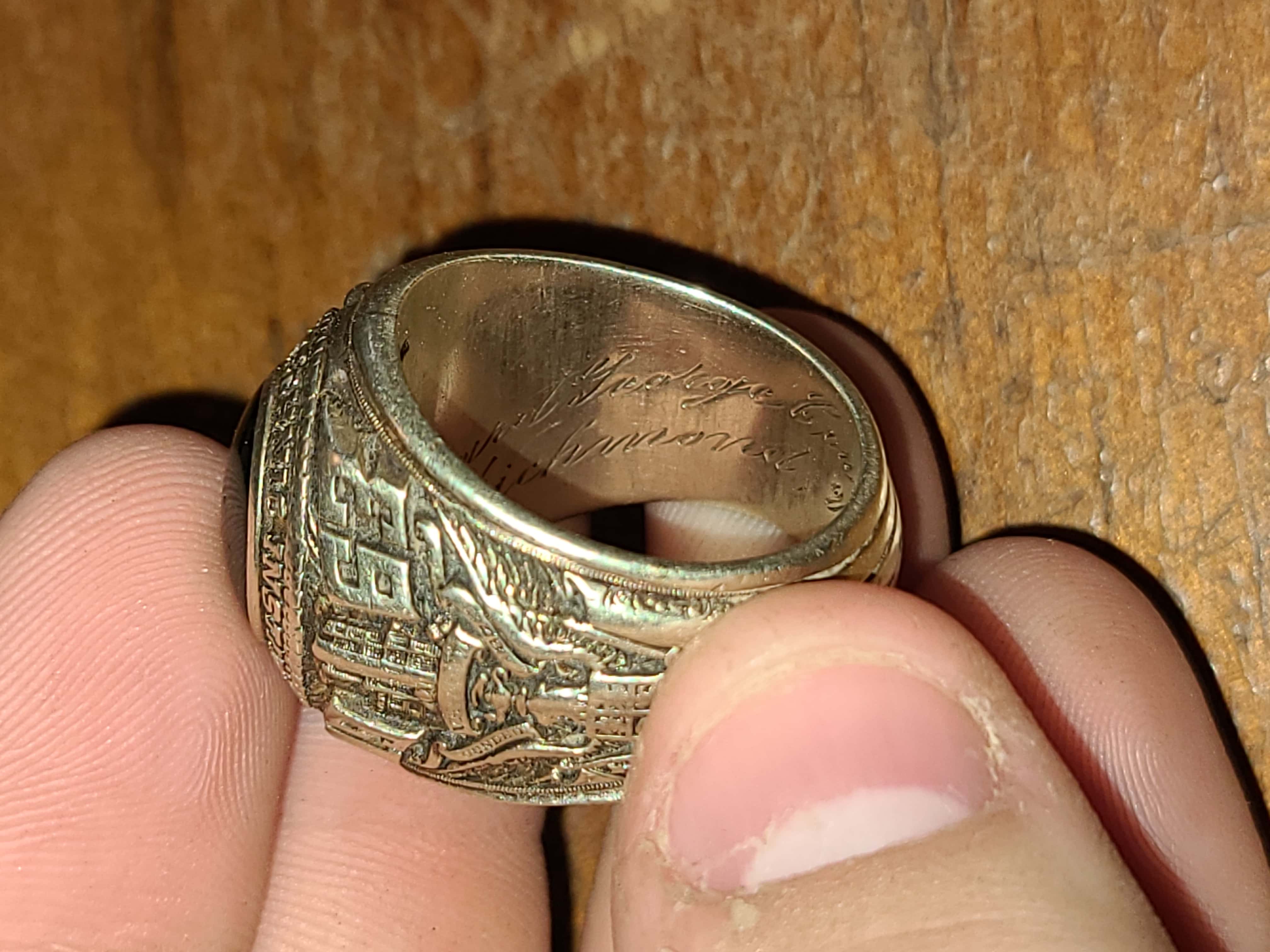 Image of Ring Held on Forefinger with Beautiful Green Colored Cabochon Gemstone or Emerald at Top and Side Showing Eagle with Shield and Year 1963