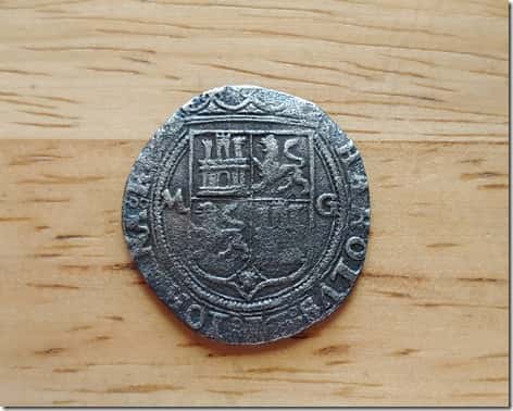 Reverse of Carlos and Juana 2 Spanish Reale Coin on Wooden Background