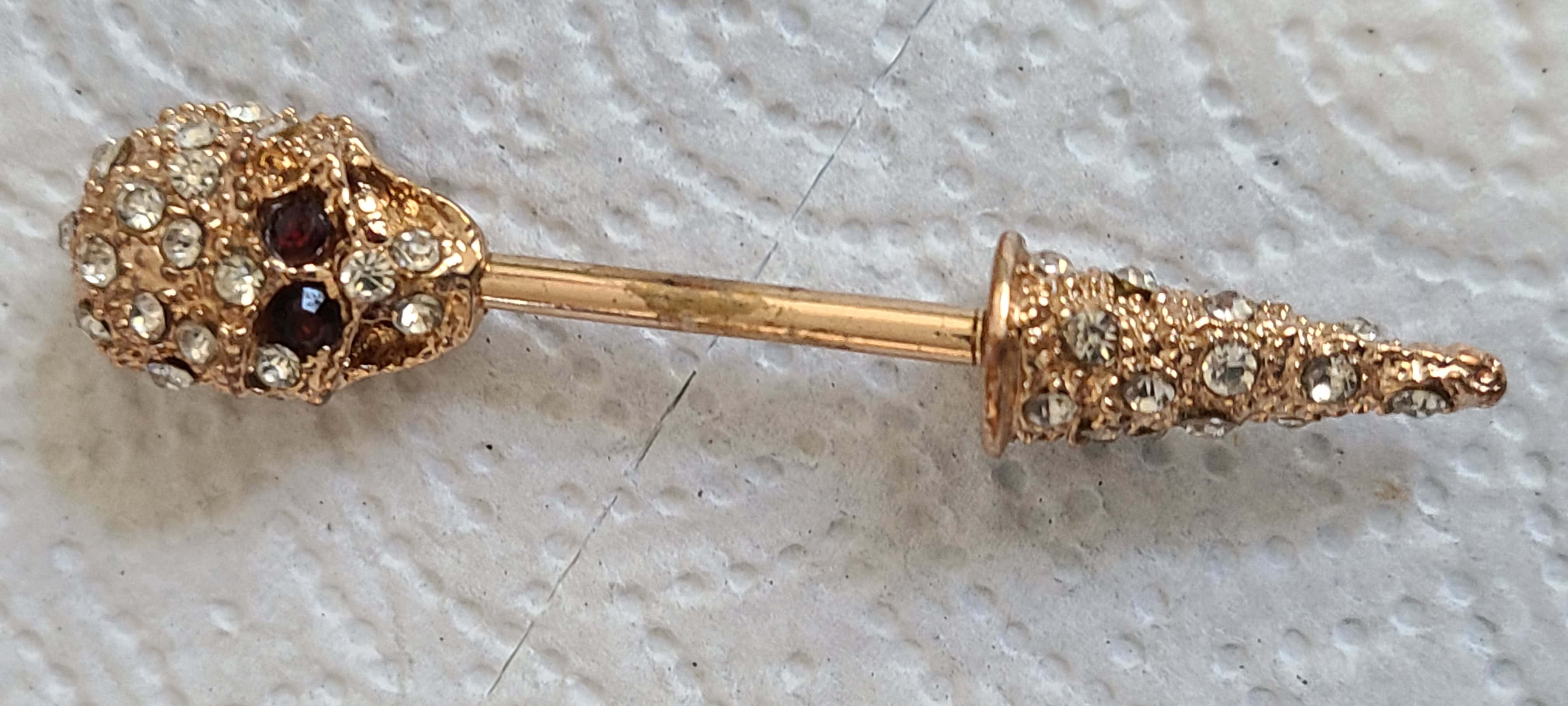 Man Holding a Find with Garrett At Pro and Headphones in Other Hand In front of House and Red Pickup Truck