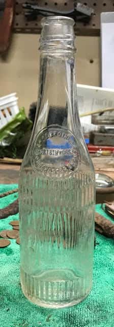 Old Ketchup Bottle in Glass on Green Towel on Old Wooden Table
